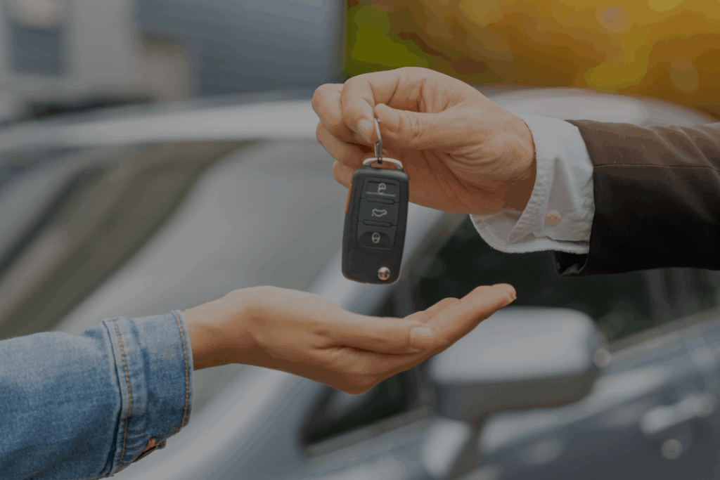 Entrega de llaves de coche entre dos personas como parte de una transferencia de vehículos.